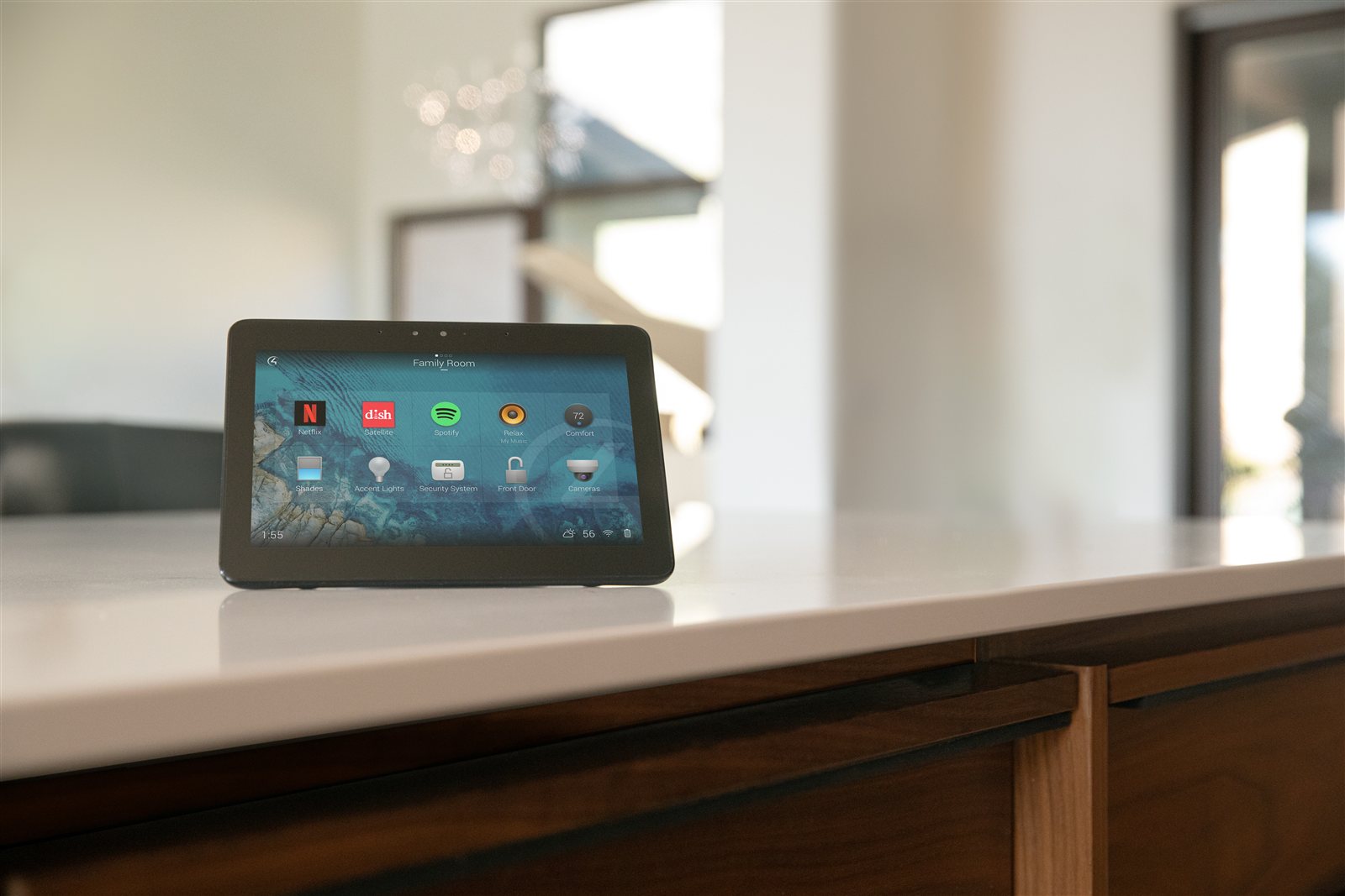 RTI touchscreen controller showing smart home automation interface in a modern kitchen